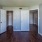 a bedroom with white doors and a wood floor